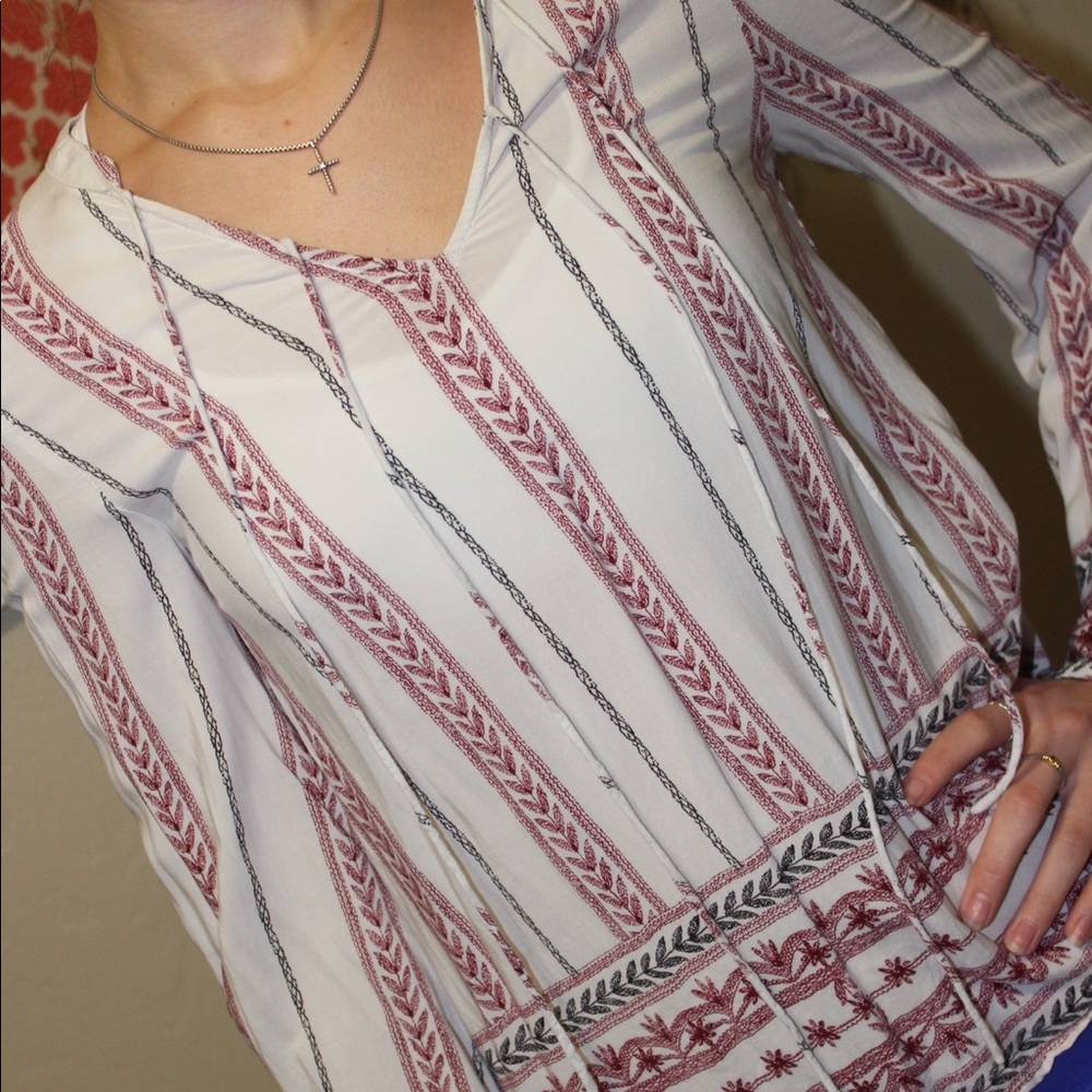 White top with red/black design and tassels.